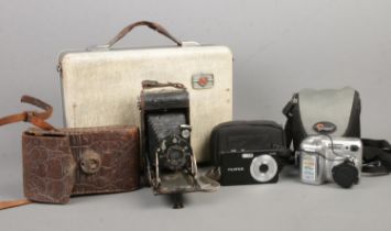 A collection of cameras, including Jubilar and Nikon Coolpix, together with a PYE portable radio.
