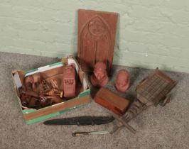 A box of wooden and African items. Includes terracotta busts, wooden cart, carved wooden animals