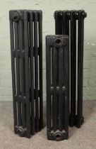 Three painted cast iron radiators; two four bar examples (86cm high) and one two bar (71cm high).
