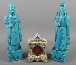 Two Oriental torquoise ceramic figures along with a faience mantel clock. Clock movement loose and