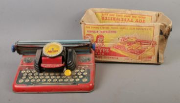 A vintage tin plate Mettype Junior typewriter with original box. Box is in very bad condition.