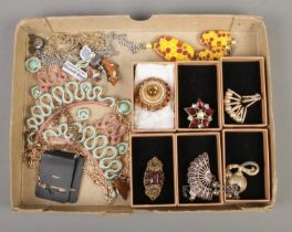 A tray of assorted costume jewellery, to include brooches and necklaces.