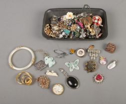 A tray of assorted costume jewellery and accessories to include necklaces, pendants, scarf clips,