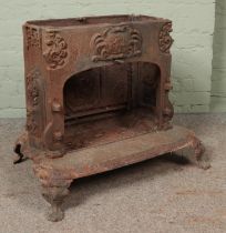 A Smith and Wellstood of Bonny Bridge cast iron log burning stove, on scrolled supports. Stamped