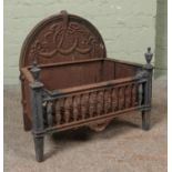 A nineteenth century cast iron and brass fire grate, with arched top and swag and bow decoration.