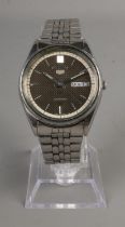 A Seiko 5 automatic water resistant men's watch with black face and luminescent hands. Day and