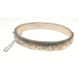 A hallmarked (Birmingham 1961) silver snap-shut bangle with safety chain and chased design, weight