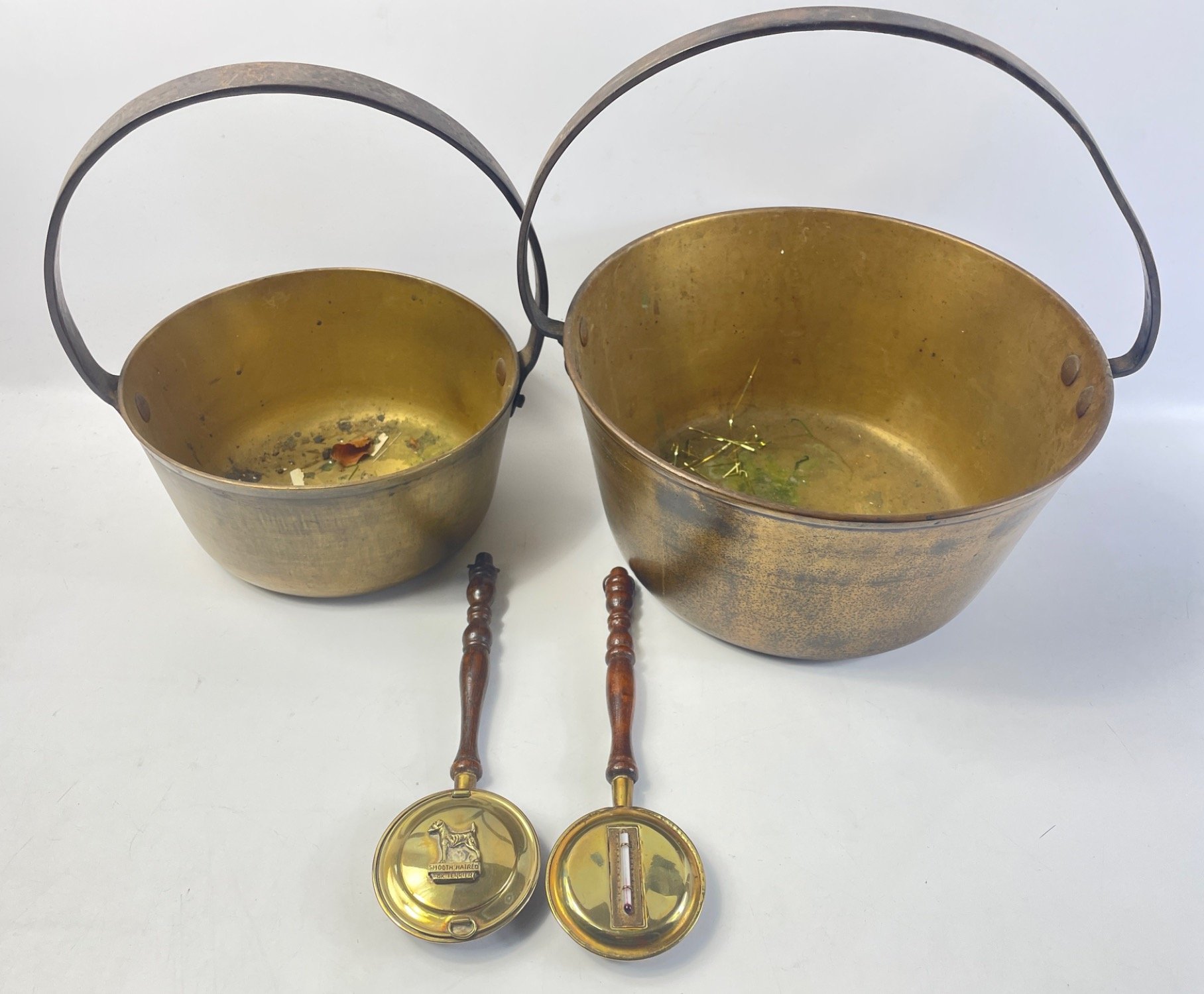 A brass jam pan 28cm diameter plus a smaller one approx 21cm as well as 2 decorative warming pans