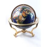 A globe with stone inlay on a brass stand