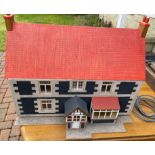A VINTAGE dolls house with removable roof and side section with furniture and lights (lights and