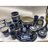 A large collection of dark blue WEDGWOOD jasperware to include a small mantel clock12cm tall and