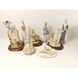 Four NAO style figurines plus three LEONARDO figurines all heavily garnished with flowers and a