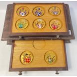 An attractive small two drawer collectors cabinet containing eight Portuguese bronze medallions by