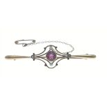 A vintage bar brooch stamped 15ct set with 4 seed pearls and a central pink stone with safety
