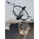 A metal armillary sundial mounted on a block of wood 95cm high x 35cm wide