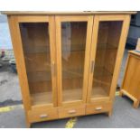 A nice modern light oak three door display case with 3 shelves - ideal for books or all those fab
