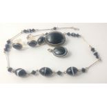A small collection of black with a white stripe jewellery to include a brooch (2.5cm), a necklace