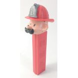 A vintage FIREMAN PEZ dispenser with hat and moustache, no feet, Hong Kong Red Stem Fire Fighter