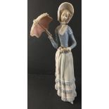 A graceful LLADRO female figurine bearing a delicately fashioned parasol