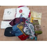 A small box full of silk scarves and various linens to include 2 packs of 4 new napkins, 2 cotton
