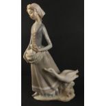 A LLADRO female figurine of a country girl nestling a gosling in her apron followed by a concerned
