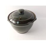 A large VELLOW, SOMERSET studio pottery lidded casserole dish with dark green/grey glaze stands