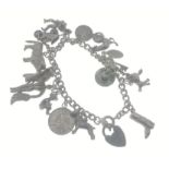 A charm bracelet with a locket stamped silver hosting 14 charms some stamped silver, Weight 48.65g