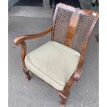 An EDWARDIAN comfortable carved mahogany bergere armchair with fabric upholstered seat