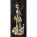 A delicate LLADRO figurine of a young woman with umbrella surrounded by ducks