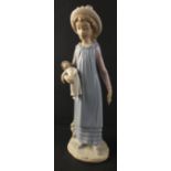 A delightful LLADRO figurine of a young girl carrying a doll in her arm