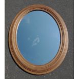A large oval mirror framed in wood, length 75 x60cm width approx