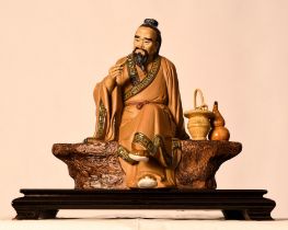 A Shiwan original figure of a finely detailed man on a bench comes with a wooden plinth