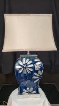 A porcelain blue and silver hand painted lamp with embossed floral detail
