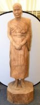 A rare life size highly detailed carving made from solid teak depicting a standing monk