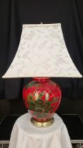 A porcelain red lacquered lamp with bird and flower hand painted detail