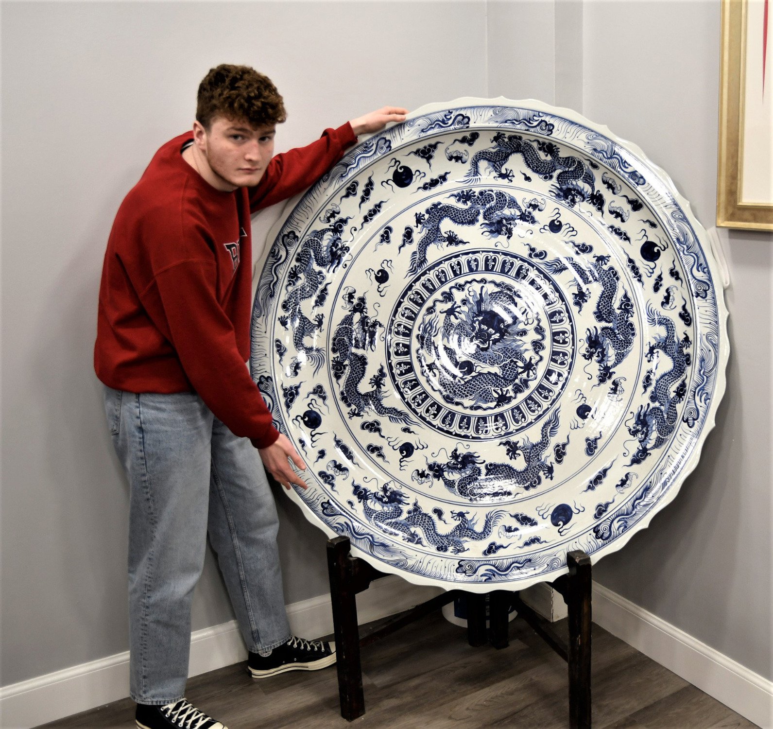 A very heavy large porcelain charger plate with a hand painted dragon design