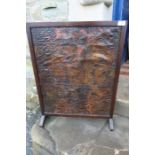 An oak firescreen, mounted with an antique polychrome decorated embossed leather panel
