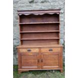 An Arts and Crafts oak sideboard, with graduated shelves, over two drawers, with cupboards below,
