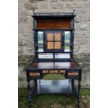 An Edwardian ebonised Arts and Crafts desk, the super-structure with central door painted with