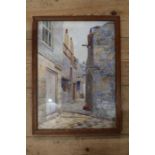 A watercolour of a street scene titled St Ives, Cornwall, indistinctly signed.