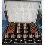 A cased set of twelve 1920s Royal Worcester coffee cans and saucers, the cans in hallmarked silver