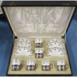 A cased set of six Royal Worcester coffee cans and saucers, decorated with garland ribbons in