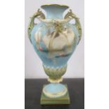 A Royal Worcester vase, decorated with swans swimming on a waterlily pond by C H C Baldwyn, with