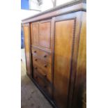 A 19th century compactum wardrobe, fitted with a cupboard over four drawers, flanked by doors