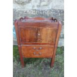 A Georgian mahogany tray top commode, with carrying handle apertures, drop down side flaps, cupboard