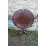 A mahogany tripod table