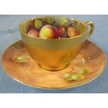 A Royal Worcester tea cup and saucer, painted to the interior of the cup with fruit by W H Austin,