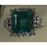 An 18ct white gold emerald and diamond dress ring, the claw-set square-cut emerald approx 13.56 mm x