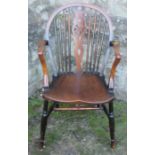 An elm seated wheel back Windsor armchair, raised on turned legs