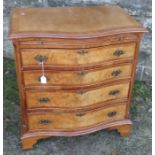 A serpentine fronted chest, of four long drawers below a cross banded top and brushing slide,